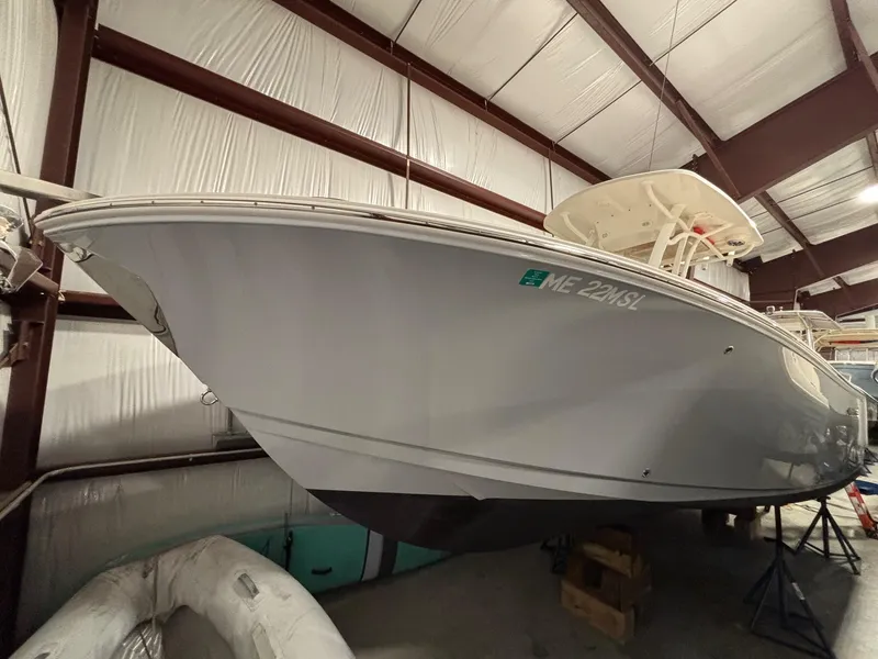 Slide: The Image of 2019 Sailfish 241 CC boat in storage, side view, indoor facility. - 2