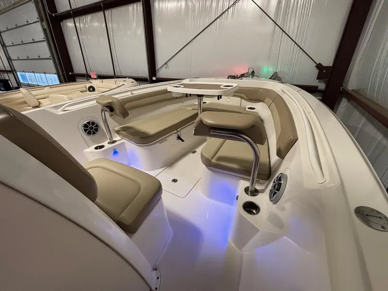 Slide: The Image of 2019 Sailfish 241 CC boat interior with beige seating and blue LED lighting. - 20