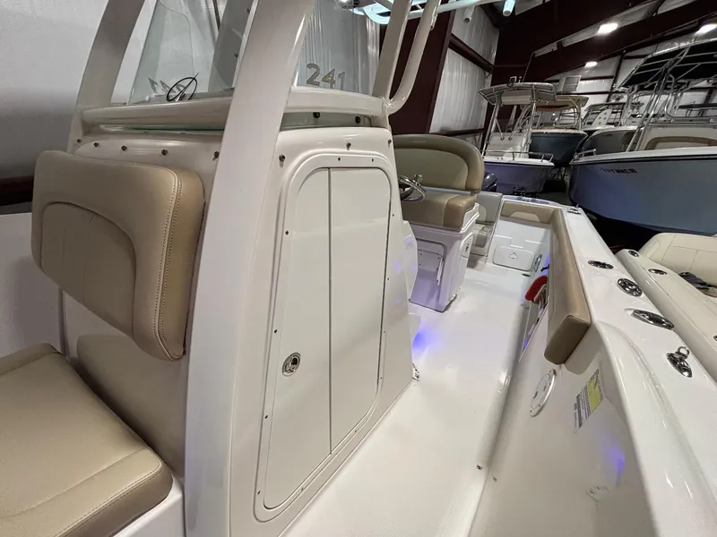 Slide: The Image of 2019 Sailfish 241 CC boat interior with beige seating and storage compartment. - 22