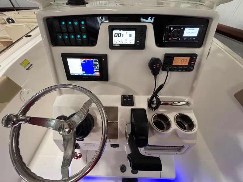Slide: The Image of 2019 Sailfish 241 CC boat dashboard with steering wheel, controls, and electronic displays. - 23