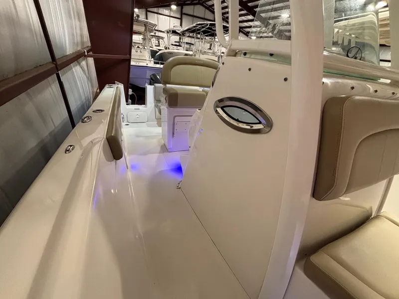 Slide: The Image of 2019 Sailfish 241 CC boat interior with beige seating and blue LED lighting. - 25