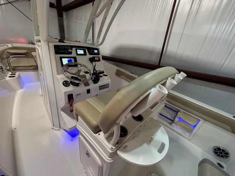 Slide: The Image of 2019 Sailfish 241 CC boat interior with helm, steering wheel, and illuminated controls. - 28