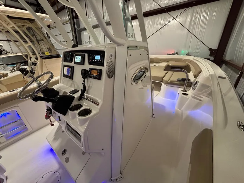 Slide: The Image of 2019 Sailfish 241 CC boat interior with illuminated console and seating area. - 29