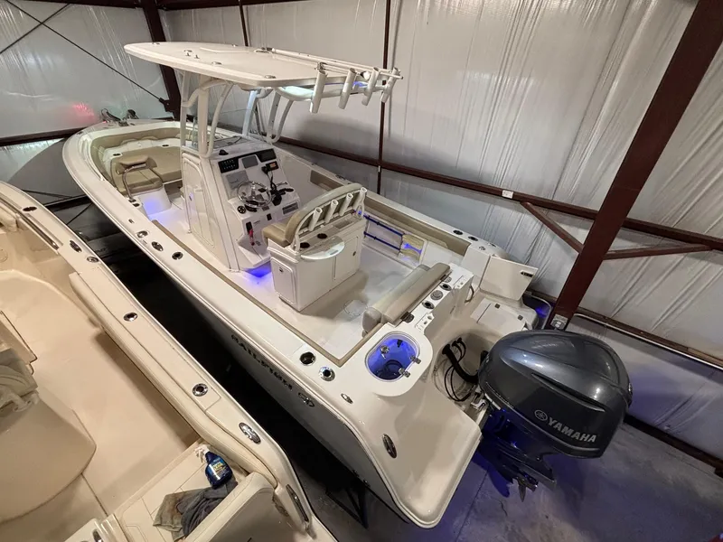 Slide: The Image of 2019 Sailfish 241 CC boat with Yamaha engine, stored indoors, featuring a center console design. - 3