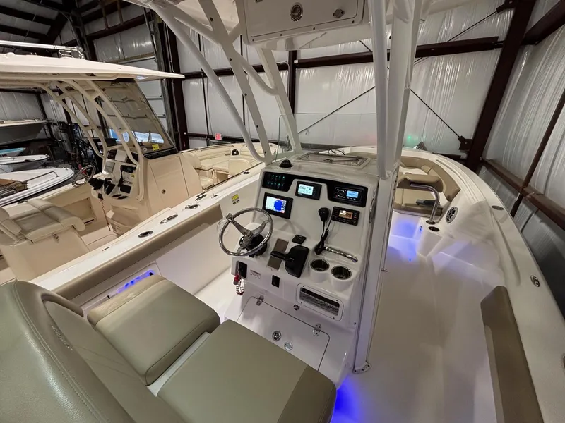 Slide: The Image of 2019 Sailfish 241 CC boat interior with modern controls and seating in a storage facility. - 30
