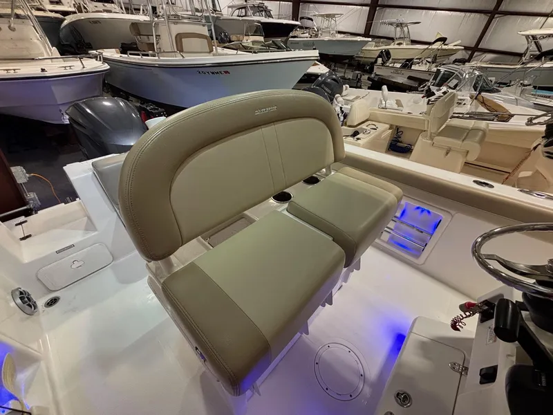 Slide: The Image of 2019 Sailfish 241 CC boat interior with beige seating in a showroom. - 31