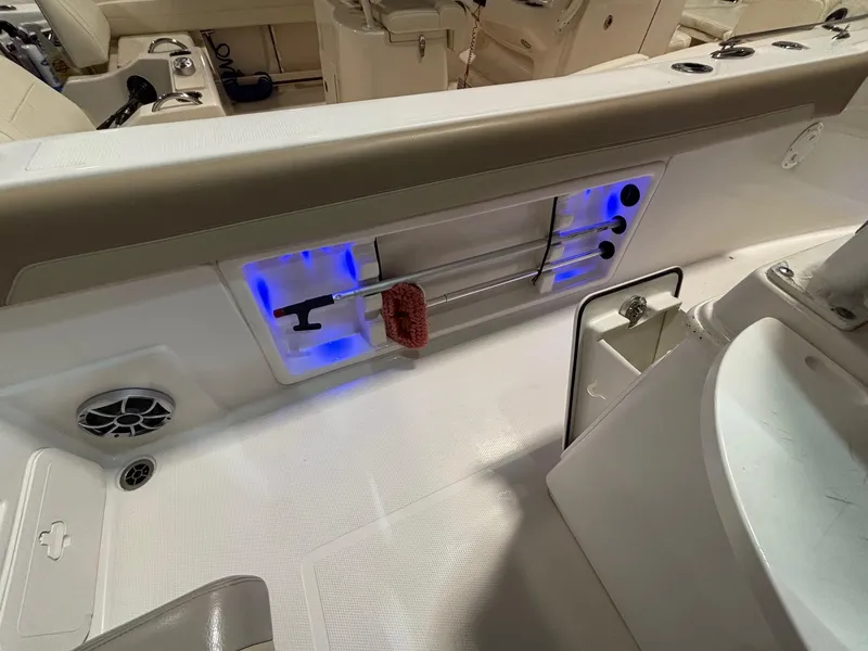 Slide: The Image of 2019 Sailfish 241 CC boat interior with rod holders and blue LED lighting. - 34