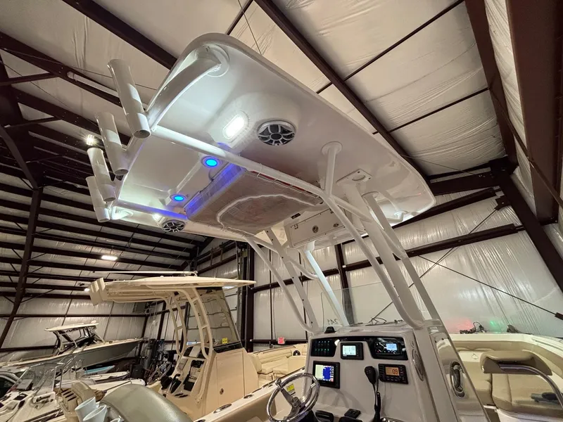 Slide: The Image of 2019 Sailfish 241 CC boat interior with illuminated T-top and control panel in a storage facility. - 37