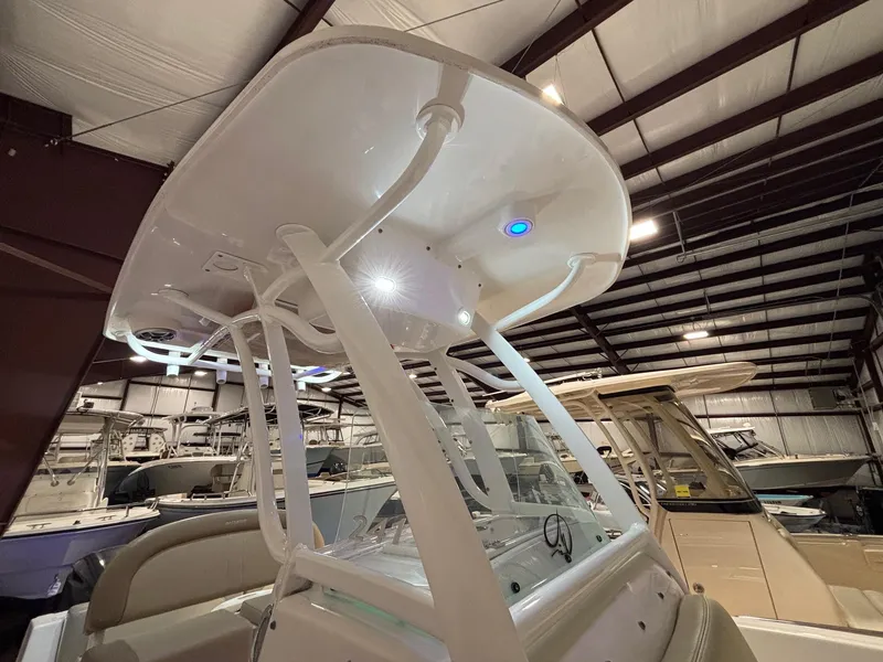 Slide: The Image of 2019 Sailfish 241 CC boat in indoor storage, featuring a sleek T-top design. - 38