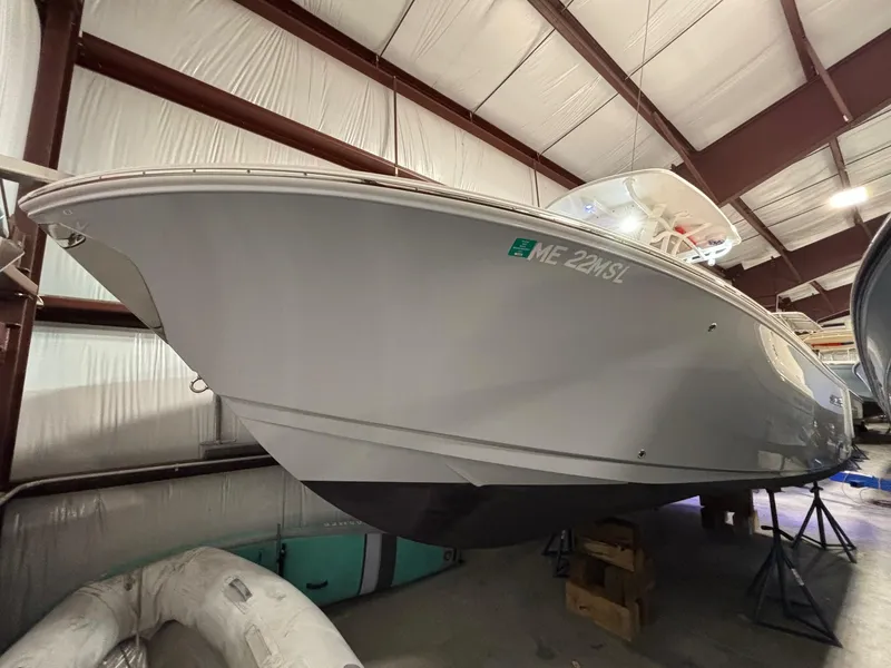 Slide: The Image of 2019 Sailfish 241 CC boat in indoor storage, elevated on stands. - 4