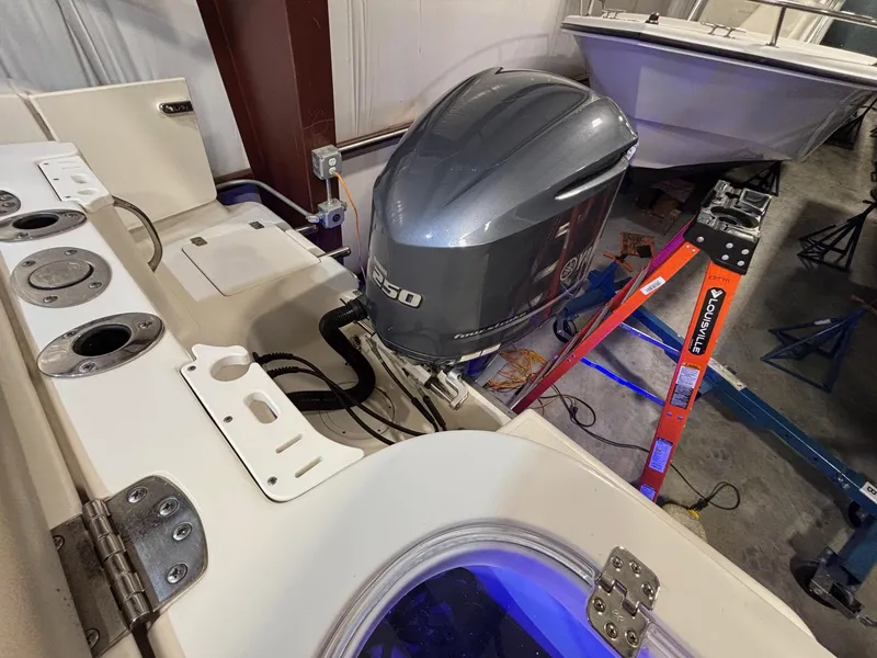 Slide: The Image of 2019 Sailfish 241 CC boat with outboard motor in a garage setting. - 44