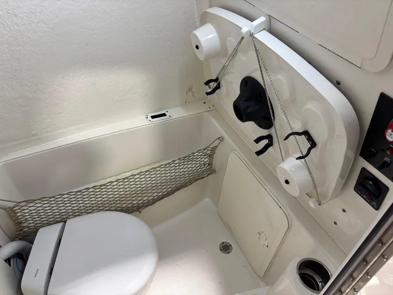 Slide: The Image of Interior of 2019 Sailfish 241 CC boat featuring compact marine toilet setup. - 46