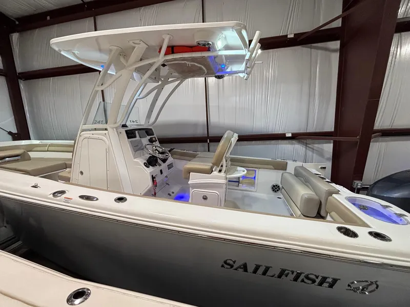Slide: The Image of 2019 Sailfish 241 CC boat in indoor storage, featuring sleek design and modern controls. - 7