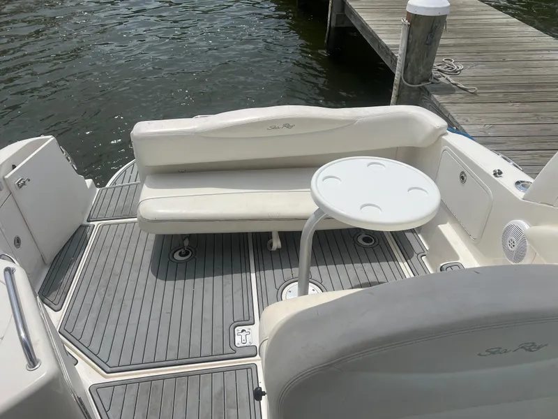Slide: The Image of 2005 Sea Ray 280 Sundancer boat interior with seating and table by the dock. - 12