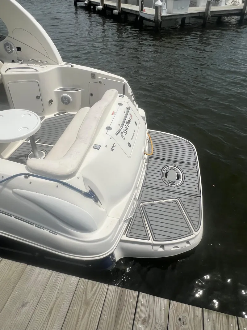 Slide: The Image of 2005 Sea Ray 280 Sundancer docked, featuring a spacious swim platform and comfortable seating. - 15