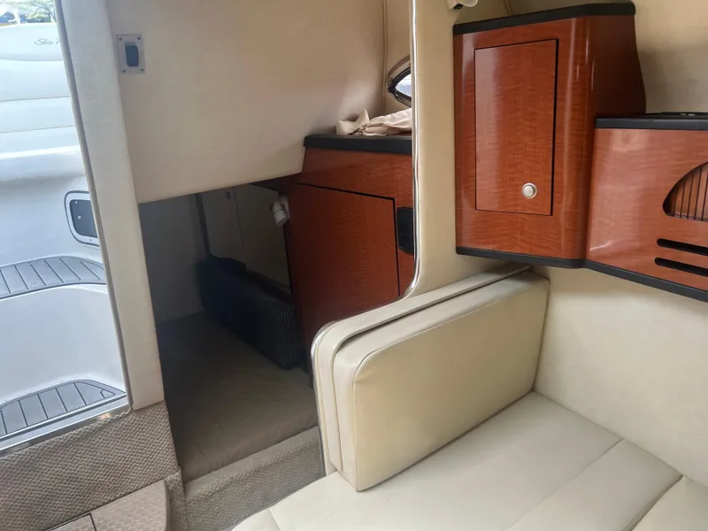 Slide: The Image of Interior of 2005 Sea Ray 280 Sundancer with beige seating and wooden cabinetry. - 17