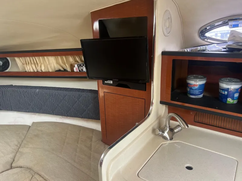 Slide: The Image of Interior of 2005 Sea Ray 280 Sundancer with TV, sink, and storage shelves. - 18