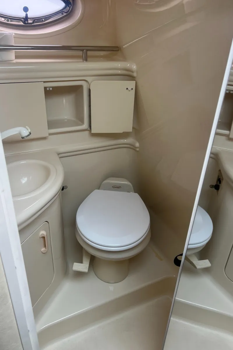 Slide: The Image of 2005 Sea Ray 280 Sundancer bathroom with sink, toilet, and storage cabinet. - 20