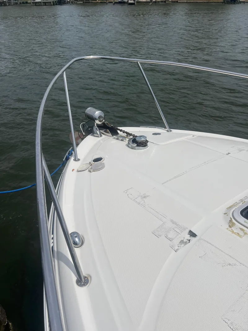 Slide: The Image of 2005 Sea Ray 280 Sundancer boat bow on water, featuring sleek design and railing. - 8