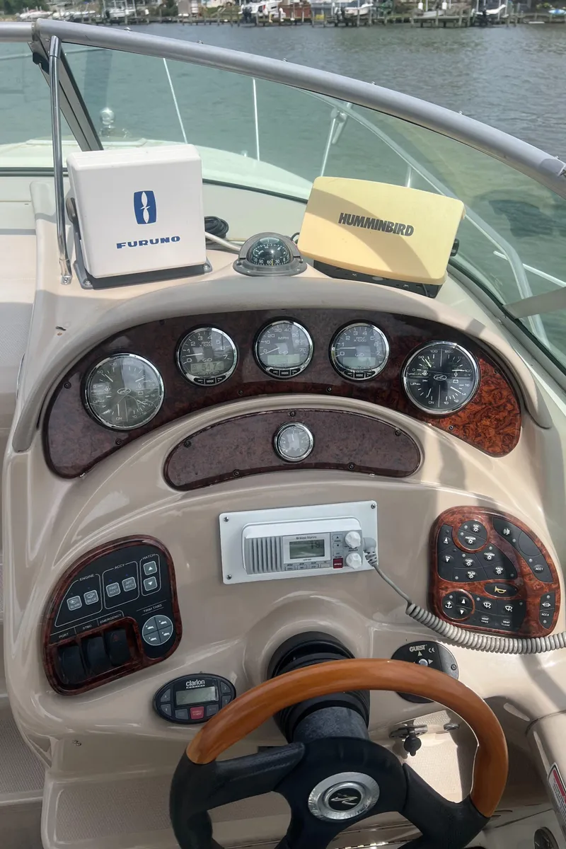 Slide: The Image of 2005 Sea Ray 280 Sundancer dashboard with gauges, steering wheel, and navigation equipment. - 9