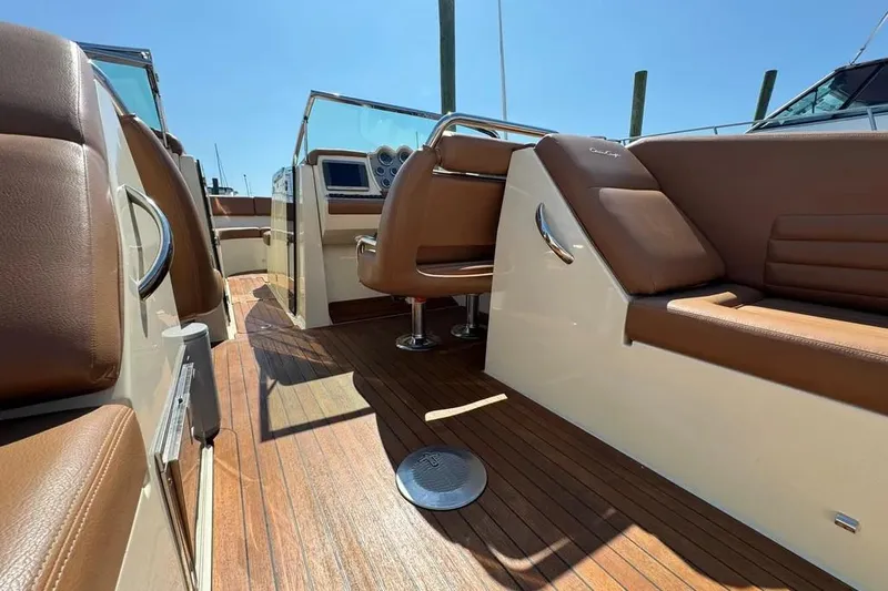Slide: The Image of 2013 Chris-Craft Launch 32 interior with brown leather seats and wooden flooring. - 14