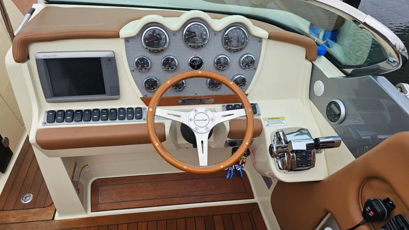 Slide: The Image of 2013 Chris-Craft Launch 32 dashboard with wooden steering wheel and modern controls. - 18