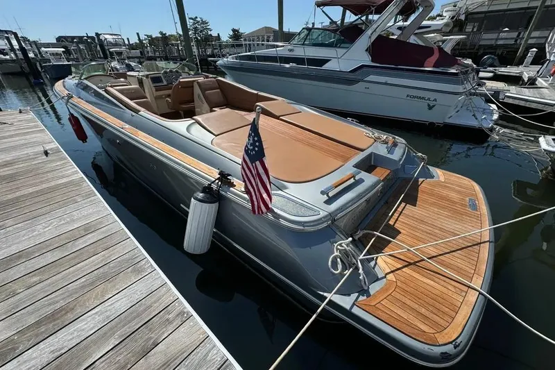 Slide: The Image of 2013 Chris-Craft Launch 32 boat docked, featuring sleek design and wooden accents. - 2
