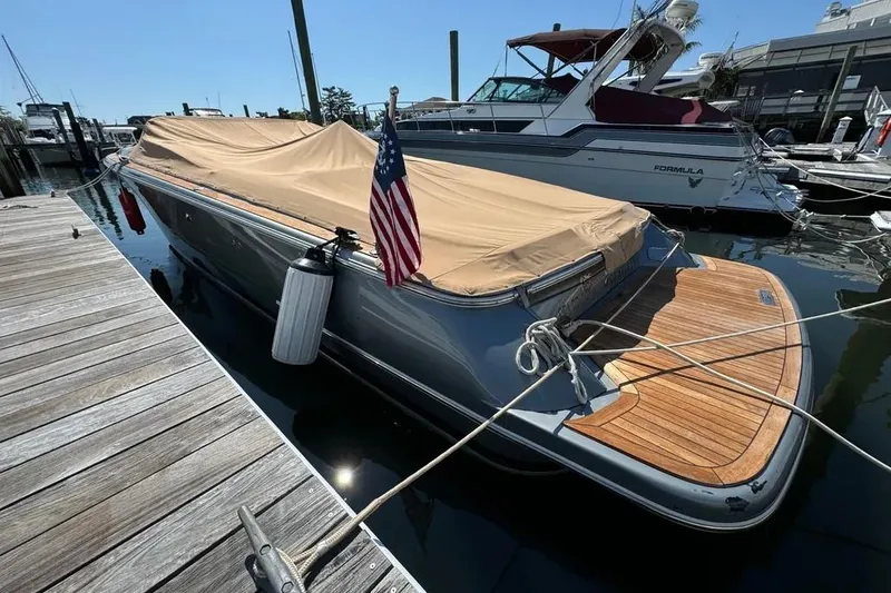Slide: The Image of 2013 Chris-Craft Launch 32 boat docked with cover and American flag. - 25