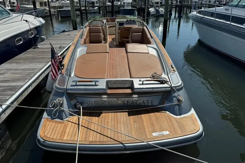 Slide: The Image of 2013 Chris-Craft Launch 32 boat docked, featuring teak decking and luxurious seating. - 3