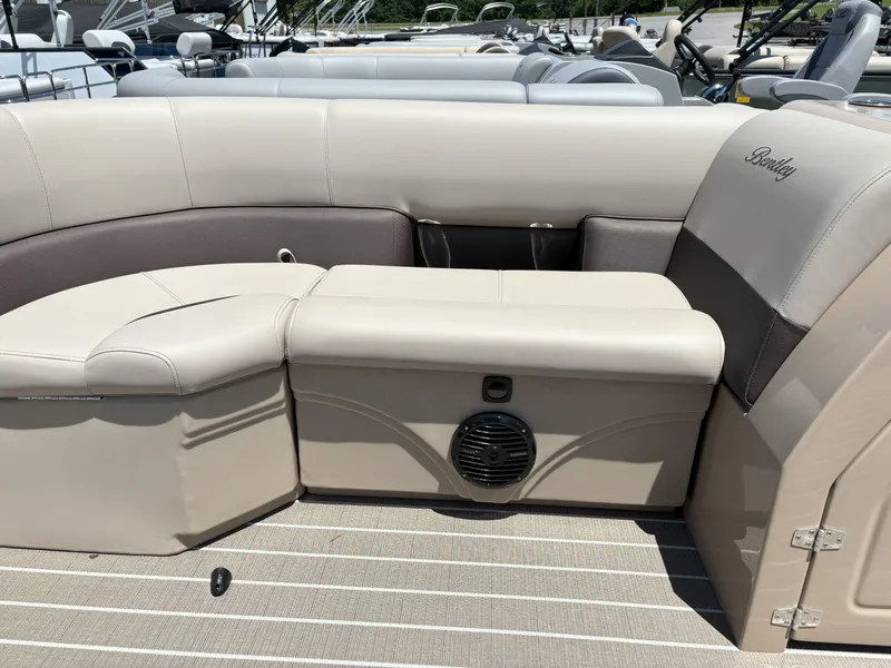 Slide: The Image of 2025 Bentley Pontoons Legacy 223 Navigator interior seating with beige upholstery and speaker. - 2