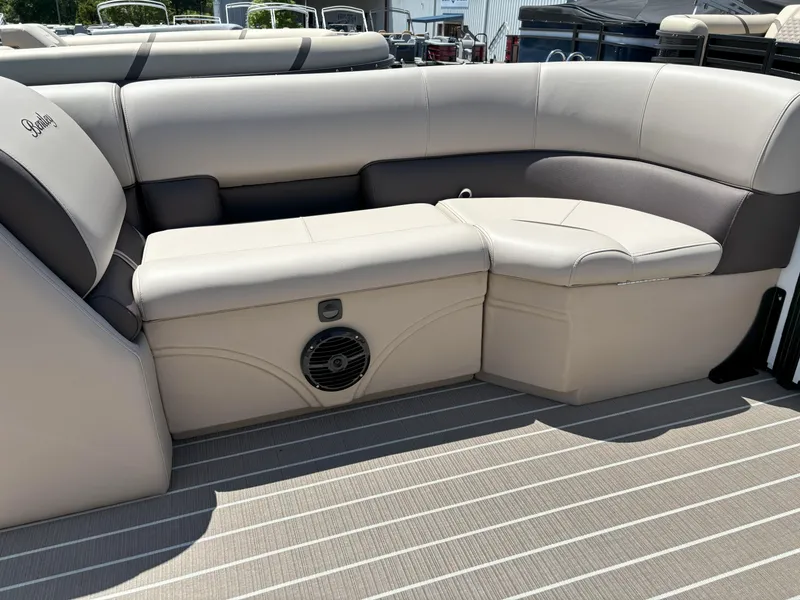 Slide: The Image of 2025 Bentley Pontoons Legacy 223 Navigator interior seating with beige upholstery and integrated speaker. - 3