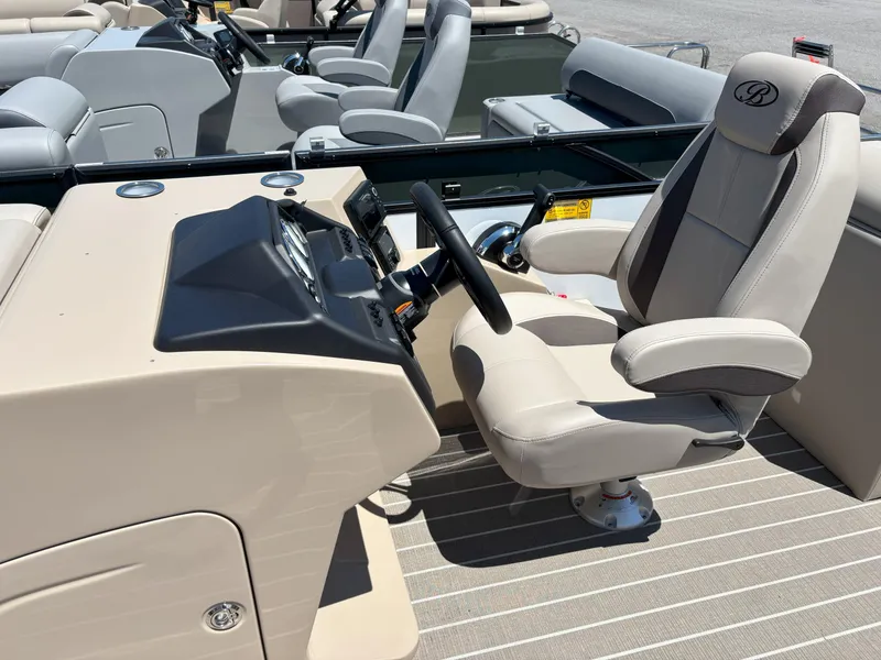 Slide: The Image of 2025 Bentley Pontoons Legacy 223 Navigator helm with beige captain's chair and steering console. - 5