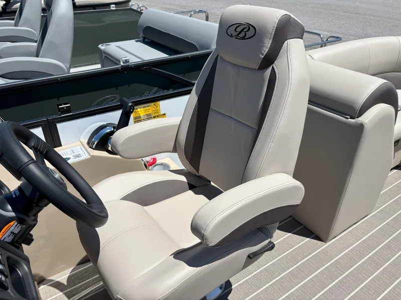 Slide: The Image of 2025 Bentley Pontoons Legacy 223 Navigator captain's chair and helm, featuring luxurious beige upholstery. - 8