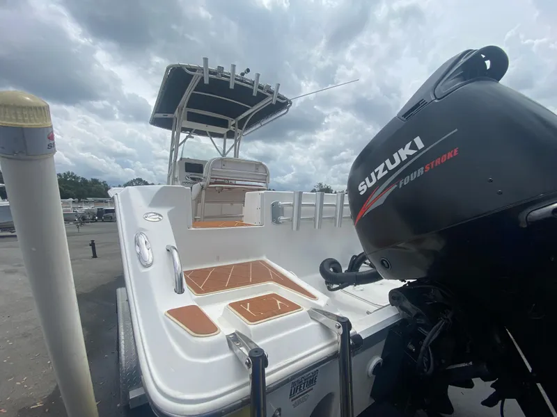 Slide: The Image of 2007 Sea Fox 256 CC boat with Suzuki outboard motor, docked under cloudy skies. - 16