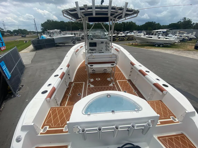 Slide: The Image of 2007 Sea Fox 256 CC boat with spacious deck and modern console, parked outdoors. - 17