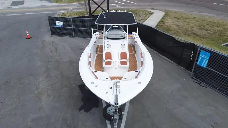 Slide: The Image of 2007 Sea Fox 256 CC boat on trailer, parked in fenced area. - 2