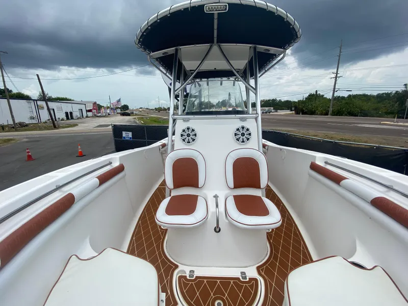 Slide: The Image of 2007 Sea Fox 256 CC boat with dual seats and canopy, docked under cloudy skies. - 24