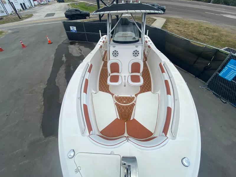 Slide: The Image of 2007 Sea Fox 256 CC boat with spacious deck and seating, parked on pavement. - 26