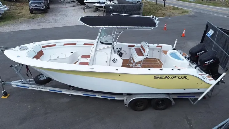Slide: The Image of 2007 Sea Fox 256 CC boat on trailer, featuring dual engines and a T-top canopy. - 3