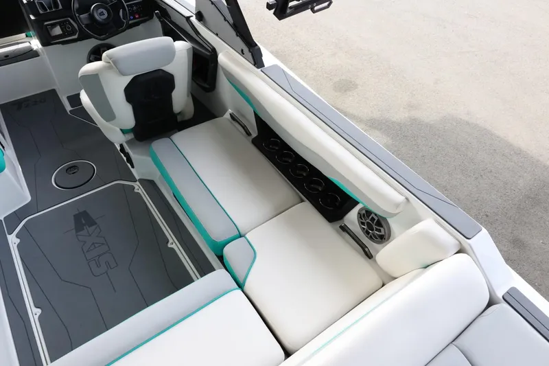 Slide: The Image of 2023 Axis T220 boat interior with white seating, teal accents, and cup holders. - 12