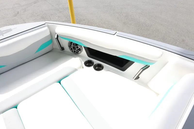 Slide: The Image of 2023 Axis T220 boat interior with white and teal seating, speaker, and cup holders. - 18