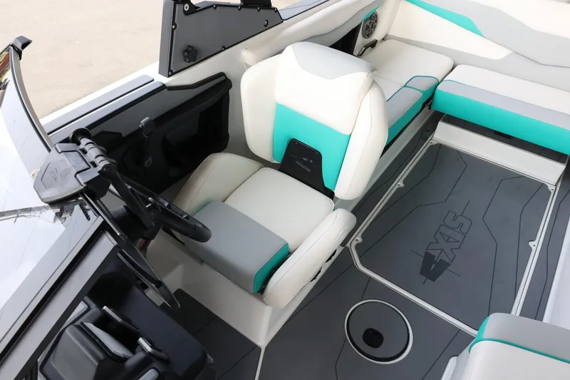 Slide: The Image of 2023 Axis T220 boat interior with white and teal seating, modern dashboard, and spacious layout. - 20