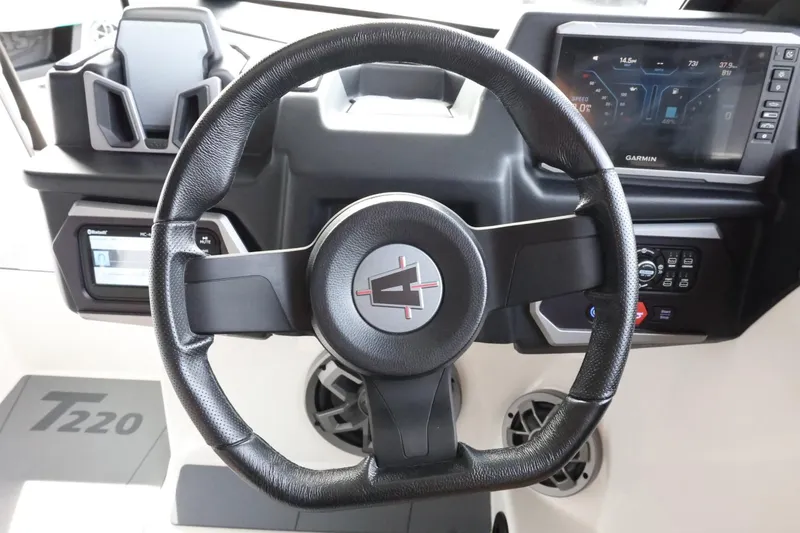 Slide: The Image of Steering wheel and dashboard of 2023 Axis T220 boat, featuring modern controls and displays. - 28