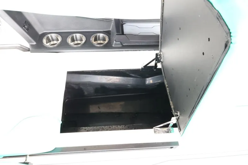 Slide: The Image of 2023 Axis T220 boat storage compartment with open lid and cup holders. - 35