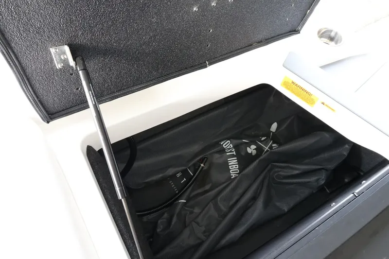 Slide: The Image of Open storage compartment in 2023 Axis T220 boat with black bag inside. - 40