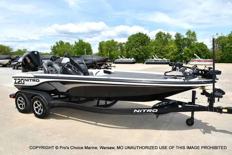 Slide: The Image of 2024 Nitro Z20 Pro boat on trailer, parked outdoors with trees in background. - 1