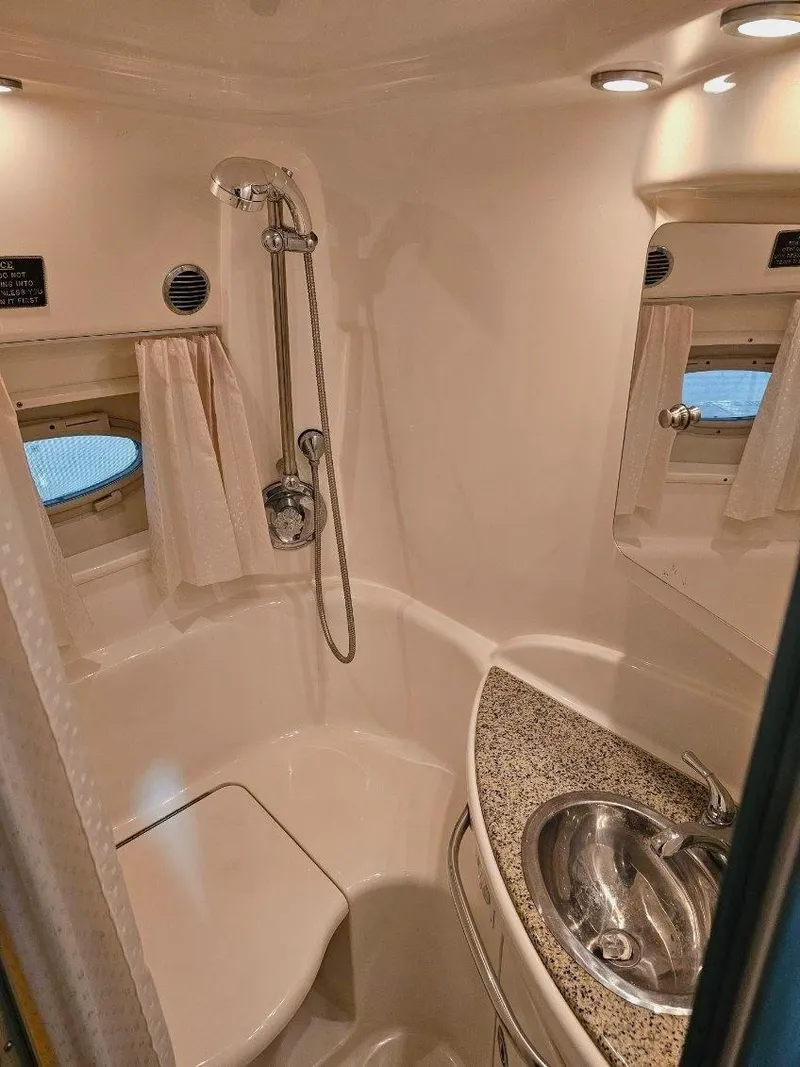 Slide: The Image of 2005 Chaparral Signature 330 bathroom with shower, sink, and porthole windows. - 11