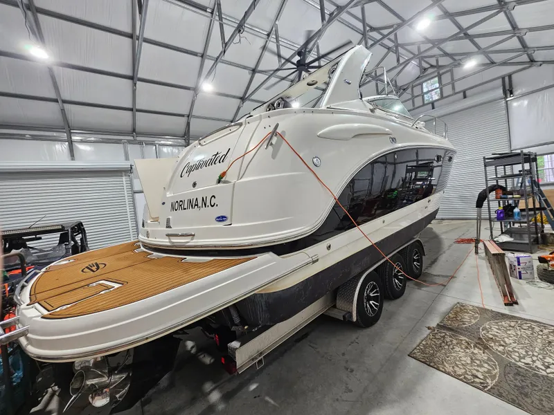 Slide: The Image of 2005 Chaparral Signature 330 boat in a garage, on a trailer, with a sleek design. - 2