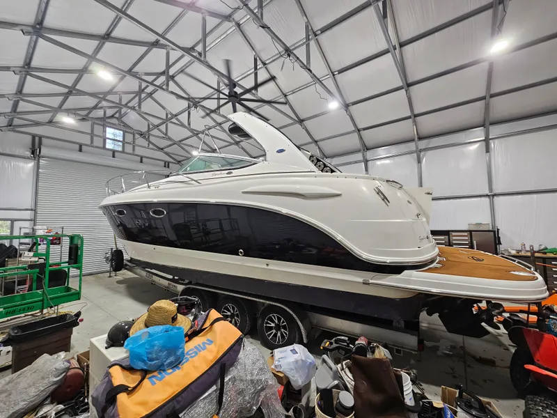 Slide: The Image of 2005 Chaparral Signature 330 boat in storage, surrounded by various equipment and items. - 3