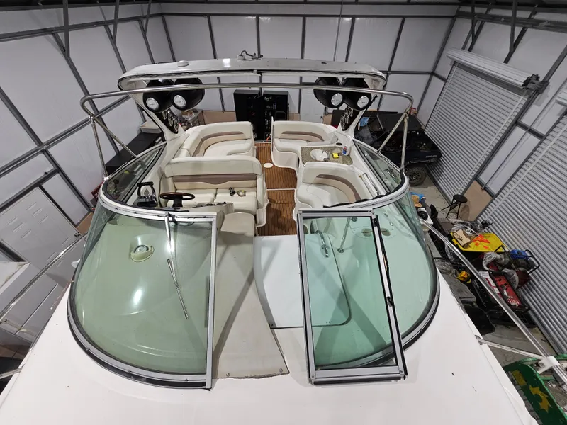 Slide: The Image of 2005 Chaparral Signature 330 boat interior with seating and open windshield in a storage facility. - 5